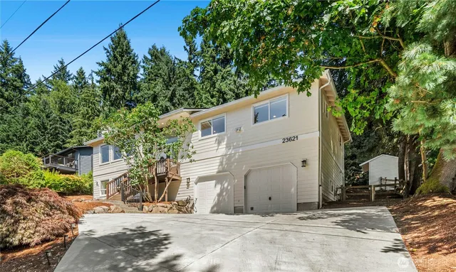 a view of a white house with a large tree