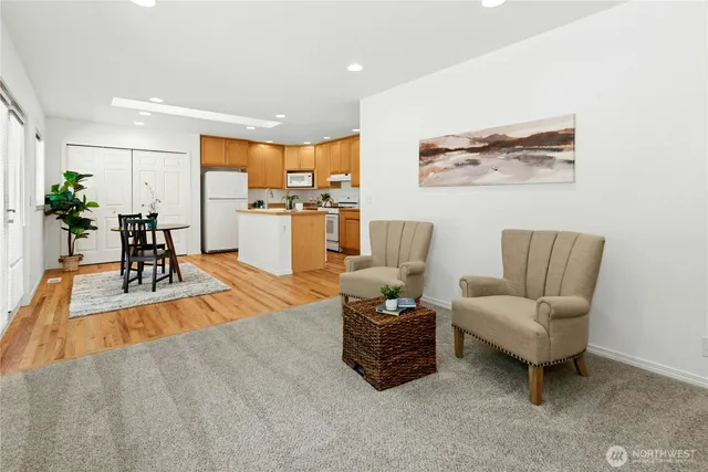 a living room with furniture and a view of kitchen