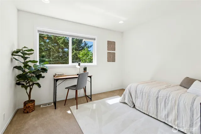 a bedroom with a bed and a potted plant
