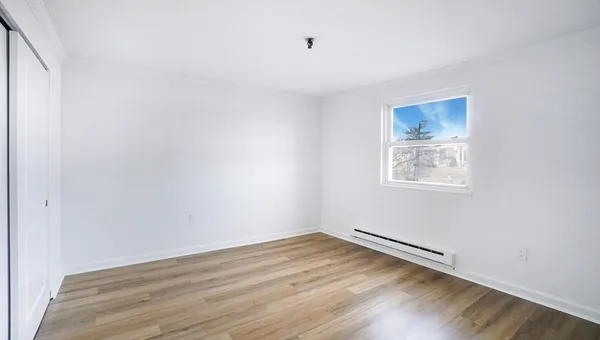 a view of a room with wooden floor and window