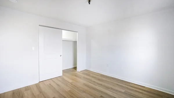 a view of an empty room with wooden floor