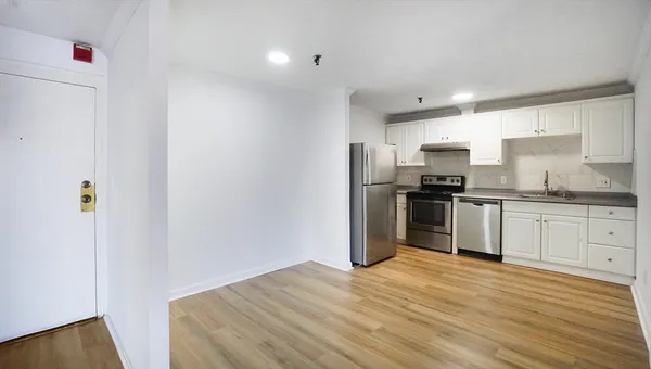 a kitchen with granite countertop a refrigerator stove top oven and sink