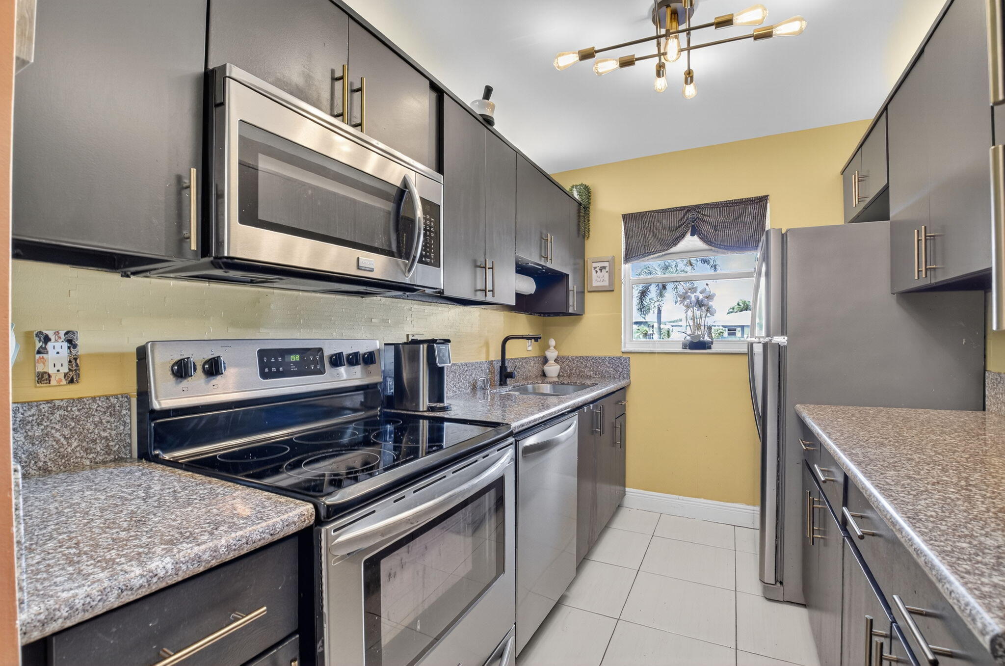 762 High Point Boulevard North, Unit D Delray Beach, FL 33445 - Photo 13 of 32 a kitchen with stainless steel appliances granite countertop a sink and a stove