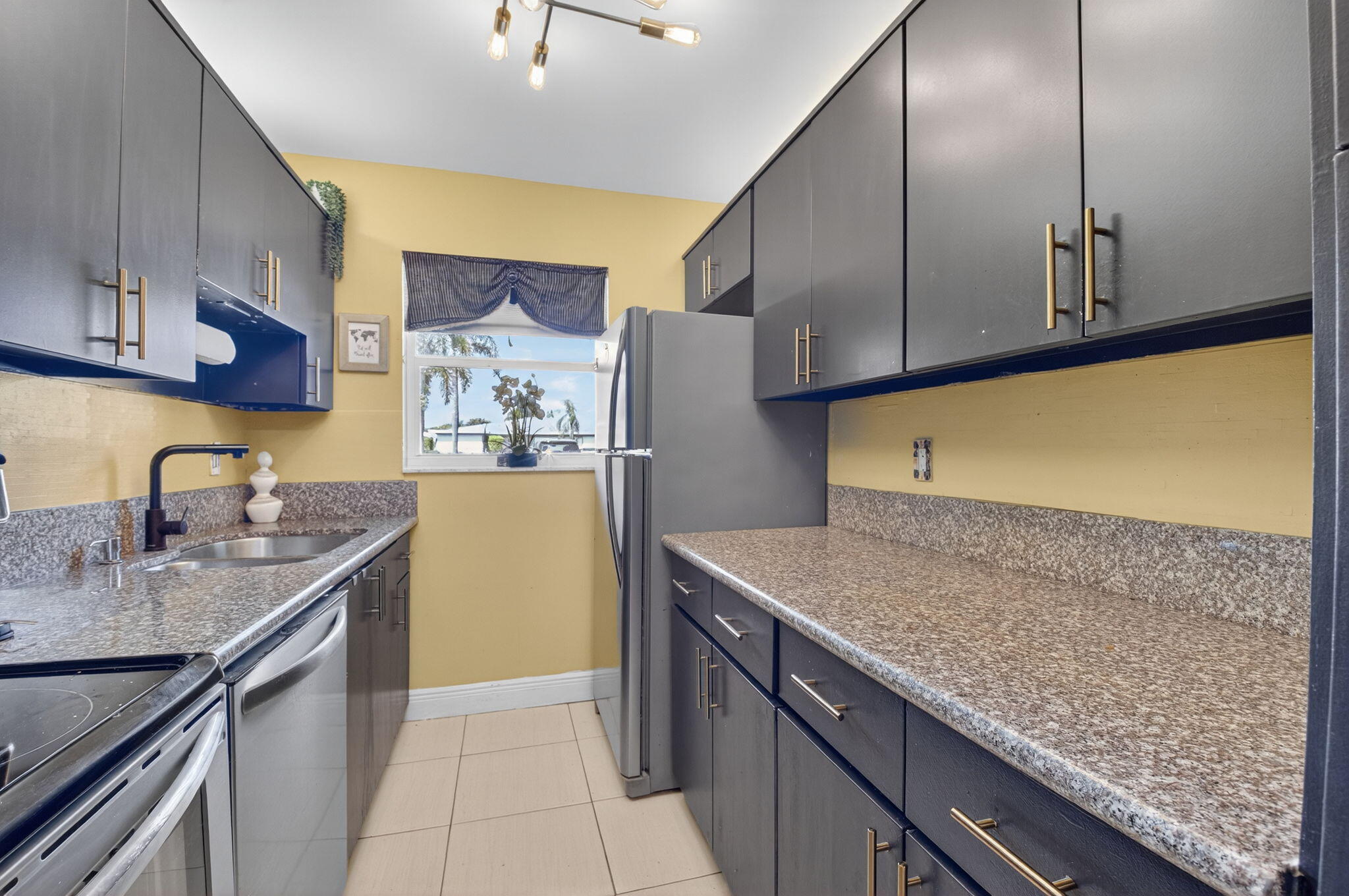 762 High Point Boulevard North, Unit D Delray Beach, FL 33445 - Photo 15 of 32 a kitchen with stainless steel appliances granite countertop a sink and a refrigerator