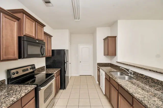 a kitchen with stainless steel appliances granite countertop a stove and a refrigerator