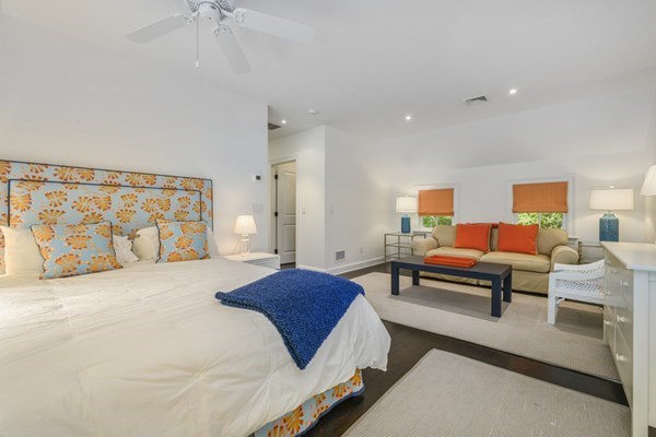 50 Nickerson Drive Barnstable, MA 02635 - Photo 19 of 36 a spacious bedroom with a bed a table and painting on the wall