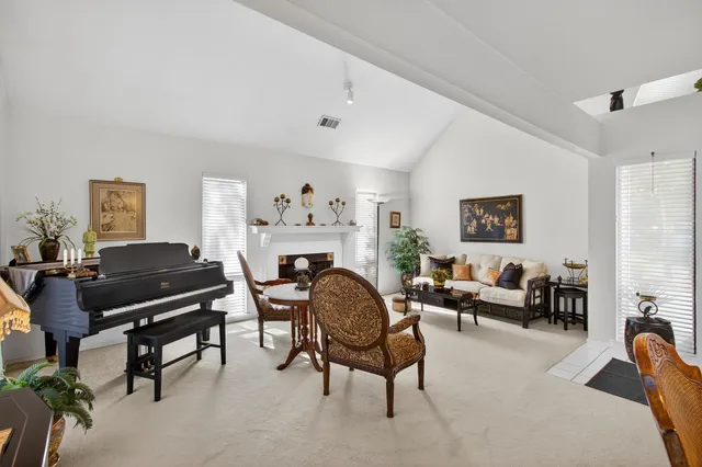 a living room with furniture a fireplace and potted plants