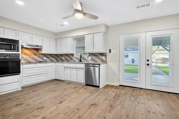 a kitchen with stainless steel appliances granite countertop a refrigerator and a sink