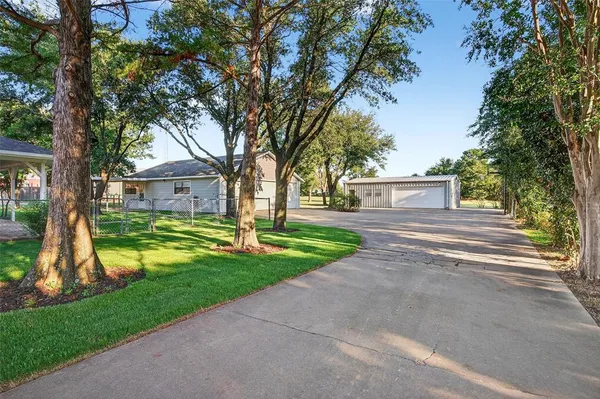 a view of a house with garden and trees