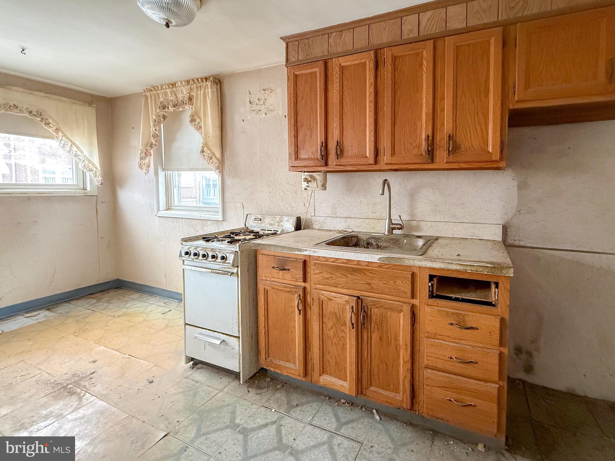 6333 Cottage Street Philadelphia, PA 19135 - Photo 9 of 23 a kitchen with stainless steel appliances granite countertop a sink cabinets and a window