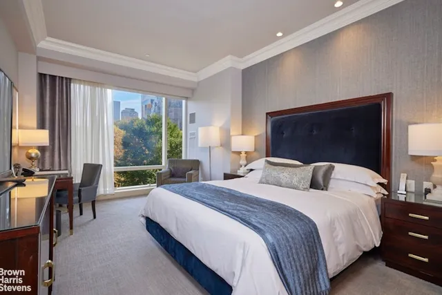 a bedroom with double bed and large windows