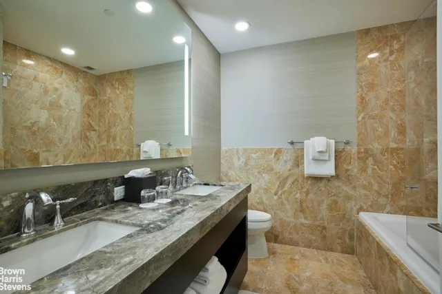 a bathroom with a granite countertop sink a mirror and a shower