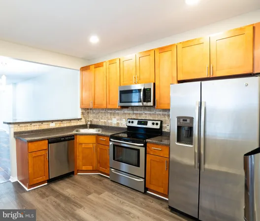 a kitchen with stainless steel appliances granite countertop a stove refrigerator and a microwave