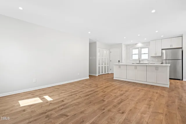 a view of an empty room with a kitchen