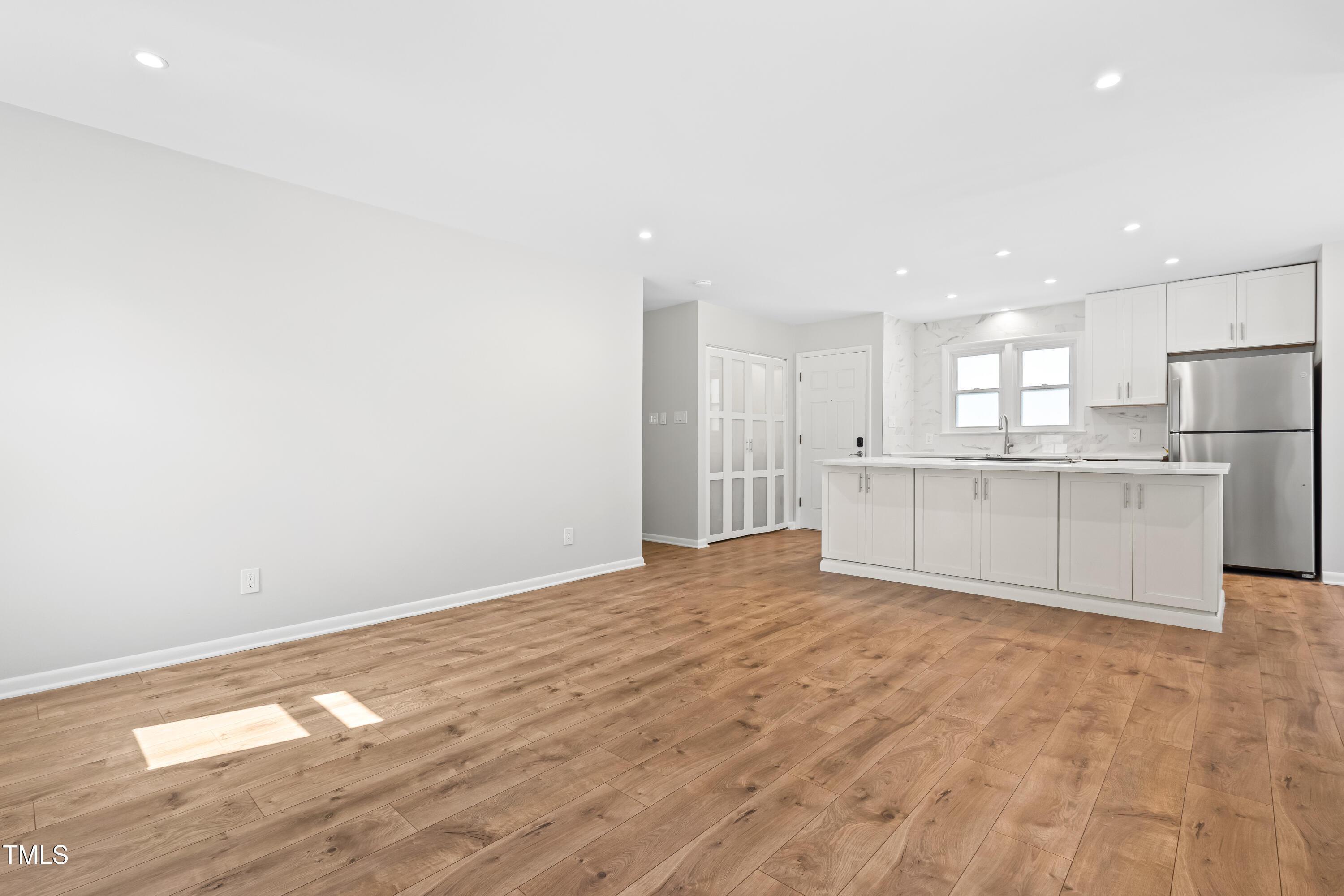 1212 Pender Street Raleigh, NC 27610 - Photo 2 of 19 a view of an empty room with a kitchen