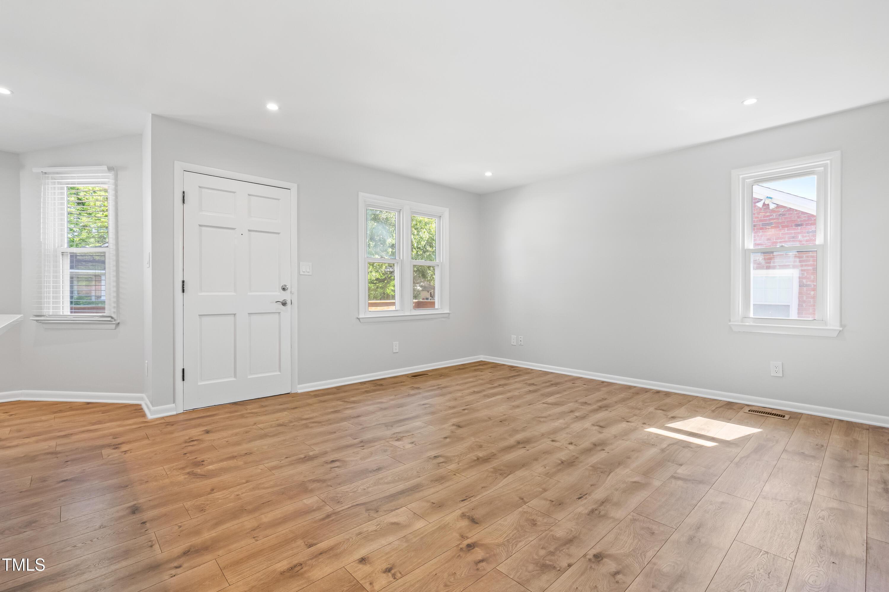 1212 Pender Street Raleigh, NC 27610 - Photo 4 of 19 a view of an empty room with wooden floor and a window