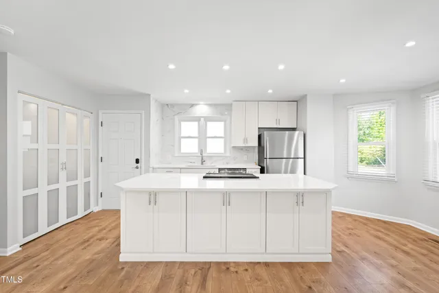 a kitchen with stainless steel appliances granite countertop a sink stove and wooden floor
