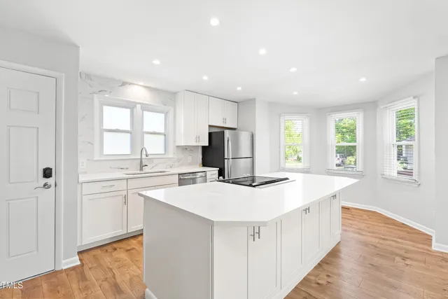 a kitchen with stainless steel appliances a sink stove and cabinets
