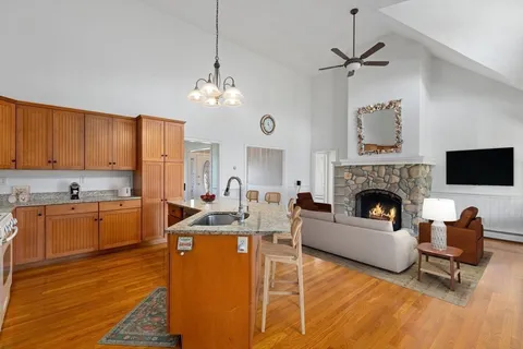 a living room with furniture a fireplace and kitchen view