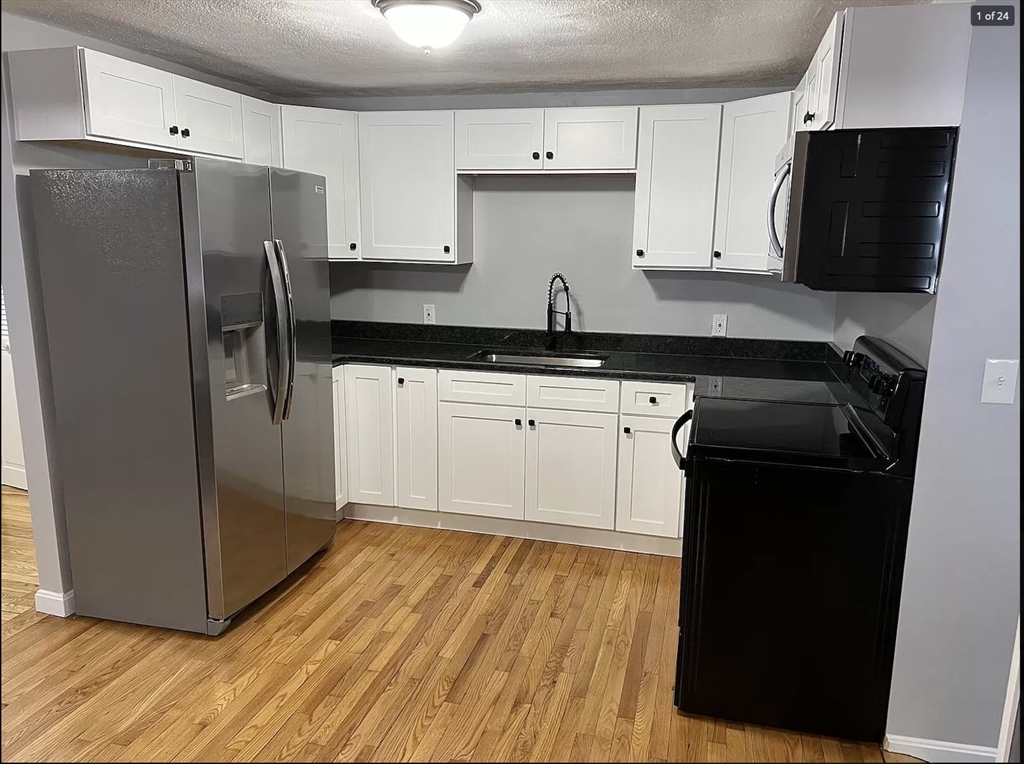 a kitchen with stainless steel appliances a refrigerator a sink a stove and cabinets