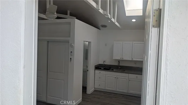 a kitchen with white cabinets and appliances