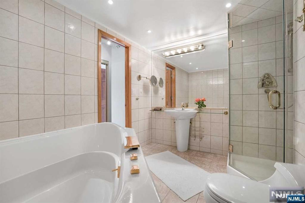1055 River Road, Unit 905 Edgewater, NJ 07020 - Photo 11 of 26 a bathroom with a bathtub toilet and shower
