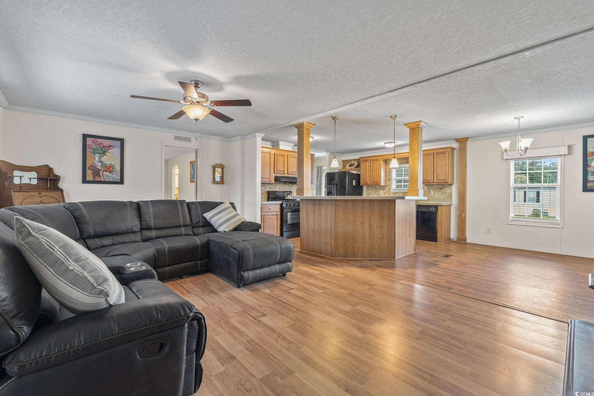 911 Old Magnolia Drive Conway, SC 29526 - Photo 11 of 35 Living area with ornamental molding, light wood-style floors, ceiling fan, a chandelier, and a textured ceiling
