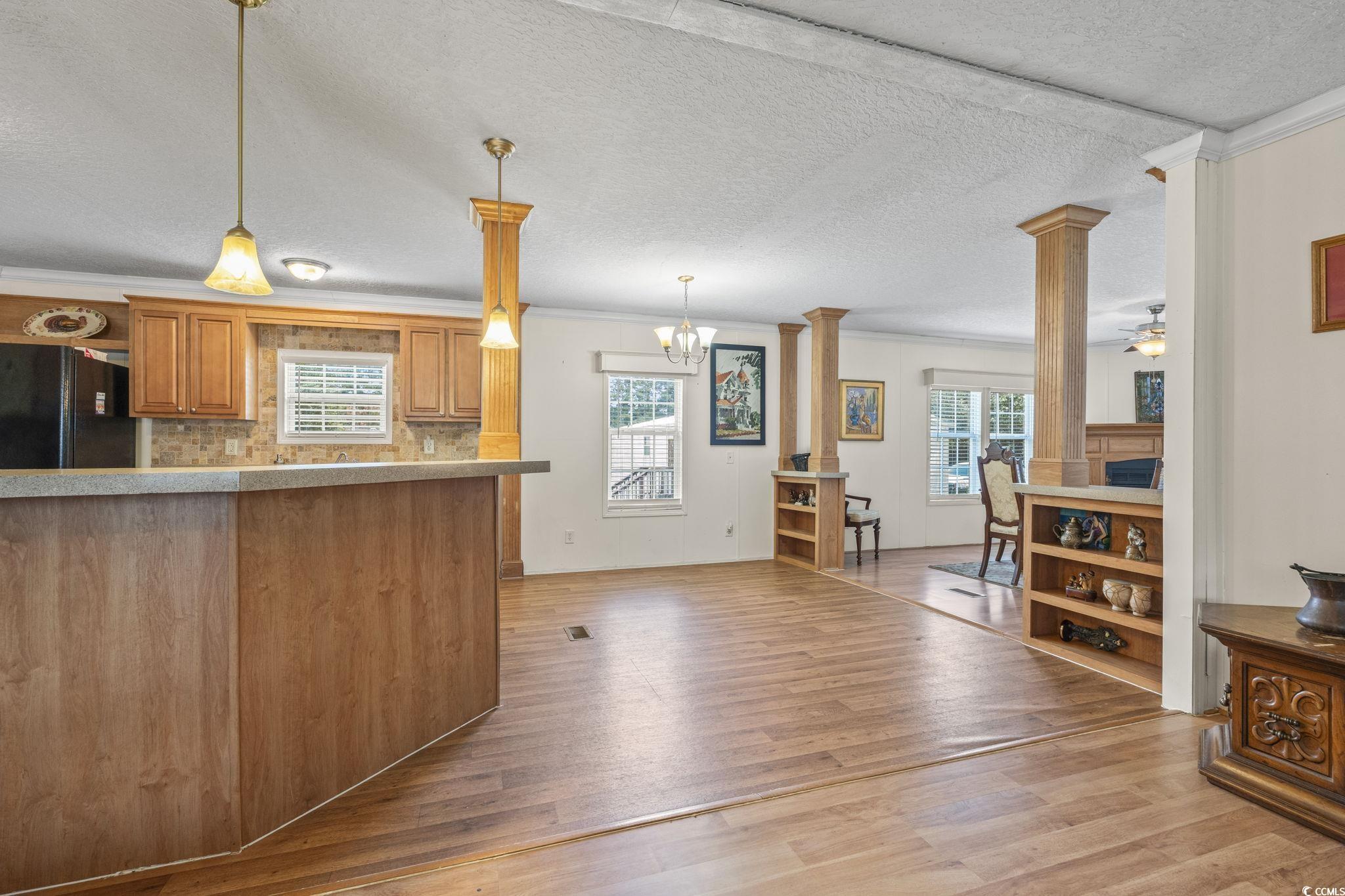 911 Old Magnolia Drive Conway, SC 29526 - Photo 13 of 35 Kitchen with crown molding, decorative columns, freestanding refrigerator, light wood-style flooring, and decorative light fixtures
