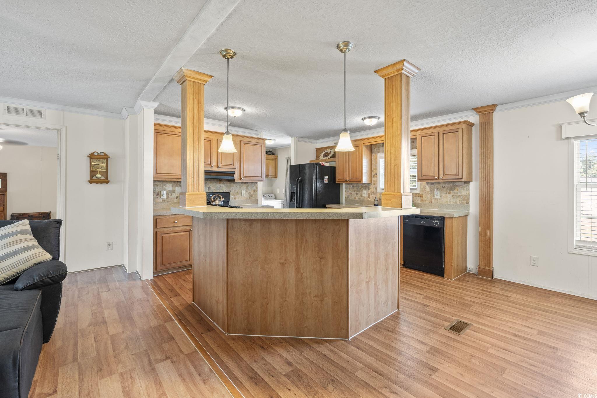 911 Old Magnolia Drive Conway, SC 29526 - Photo 33 of 35 Kitchen featuring ornate columns, open floor plan, light countertops, backsplash, and crown molding