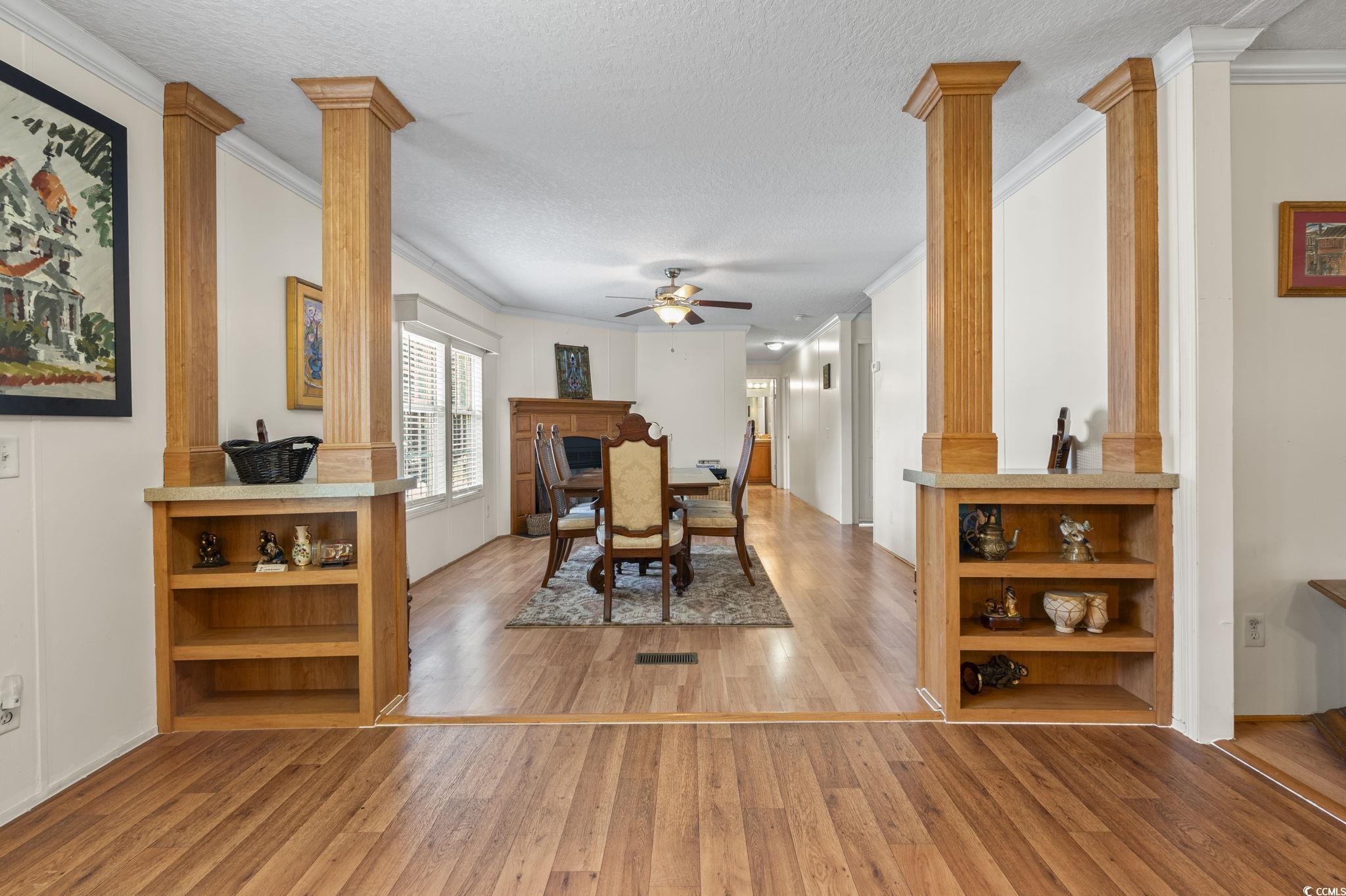 911 Old Magnolia Drive Conway, SC 29526 - Photo 17 of 35 Dining space with decorative columns, crown molding, ceiling fan, light wood-style floors, and a textured ceiling