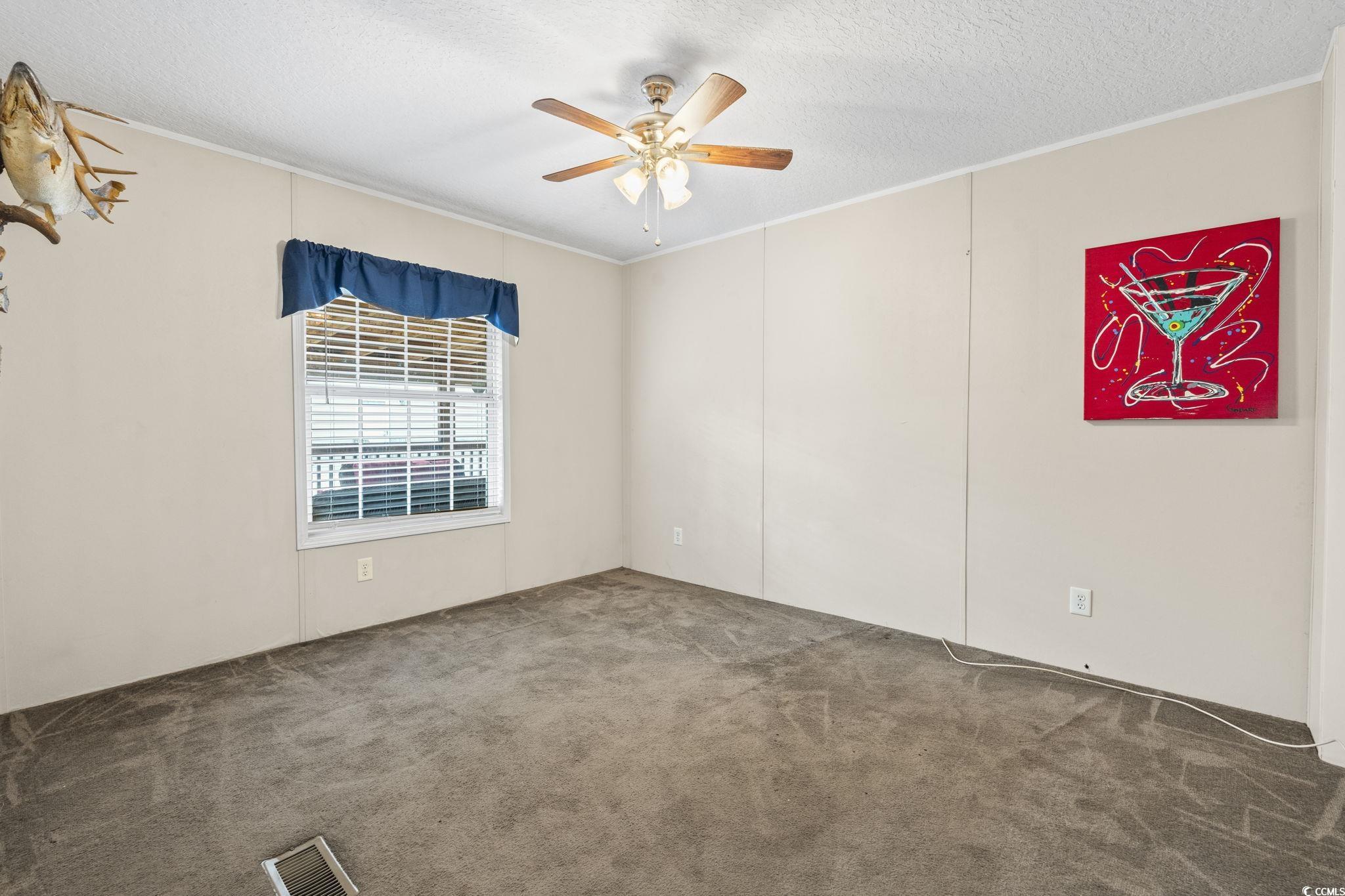 911 Old Magnolia Drive Conway, SC 29526 - Photo 19 of 35 Carpeted spare room with ornamental molding, a ceiling fan, and a textured ceiling