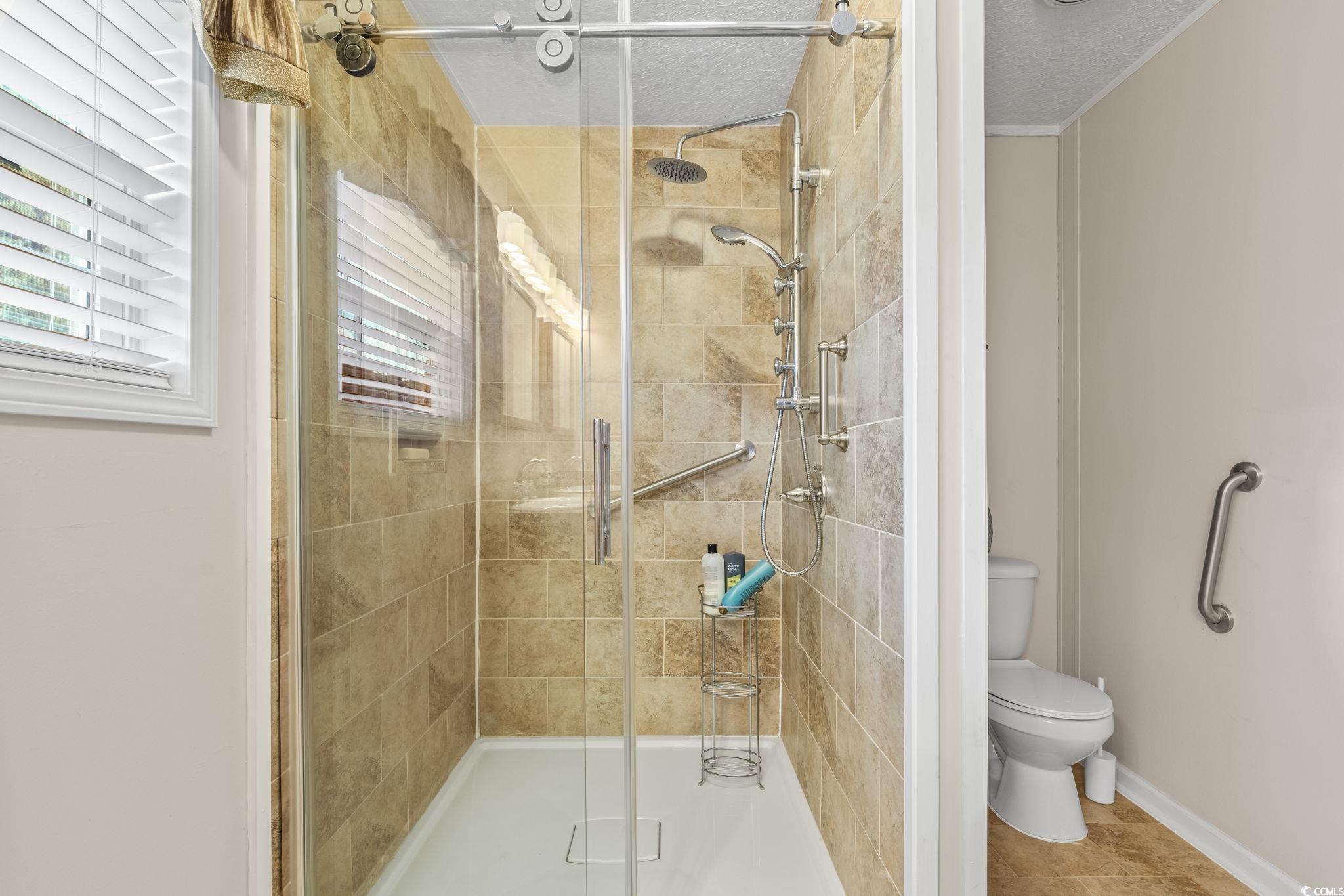 911 Old Magnolia Drive Conway, SC 29526 - Photo 24 of 35 Bathroom featuring a stall shower, crown molding, and tile patterned floors