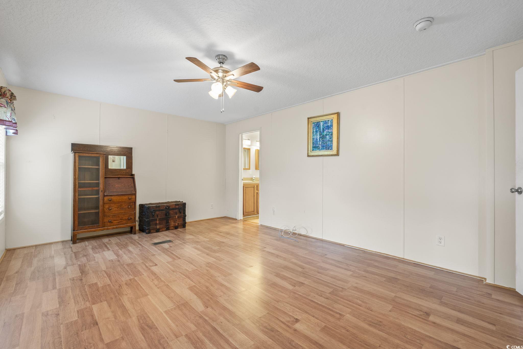 911 Old Magnolia Drive Conway, SC 29526 - Photo 29 of 35 Unfurnished living room with a ceiling fan, light wood-style flooring, and a textured ceiling