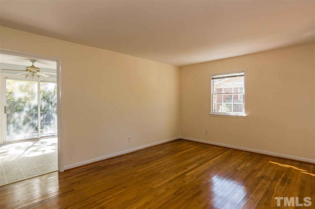 1506 Sedwick Road Durham, NC 27713 - Photo 3 of 21 a view of an empty room with wooden floor and a window