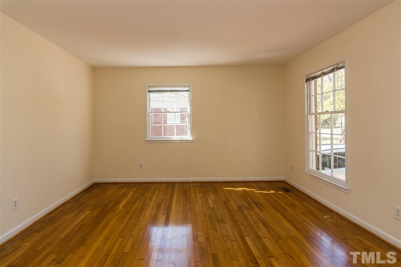 1506 Sedwick Road Durham, NC 27713 - Photo 4 of 21 an empty room with wooden floor and windows