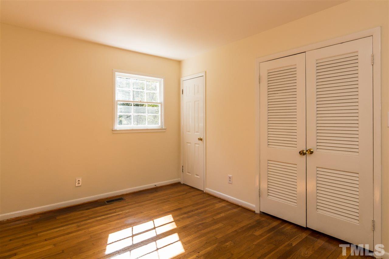 1506 Sedwick Road Durham, NC 27713 - Photo 8 of 21 a view of an empty room with wooden floor and a window