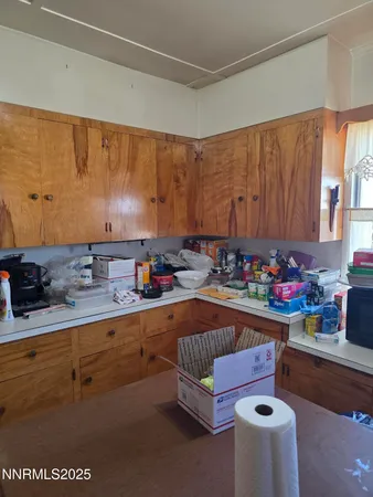 a kitchen with granite countertop lots of clutter and stainless steel appliances