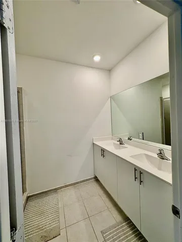 a bathroom with a double vanity sink and mirror