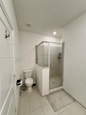 a bathroom with a granite countertop sink a toilet and shower