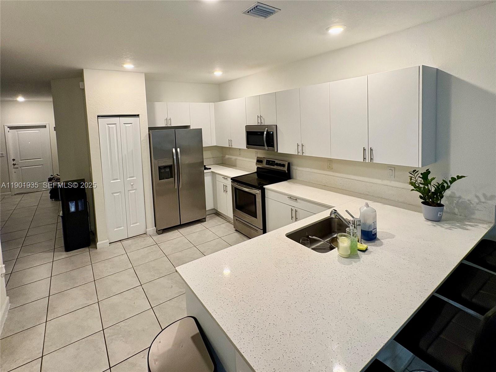 1020 Southeast 26th Street Homestead, FL 33035 - Photo 21 of 47 a kitchen with stainless steel appliances a refrigerator sink and microwave