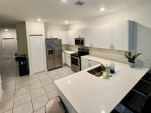 a kitchen with stainless steel appliances a refrigerator sink and microwave