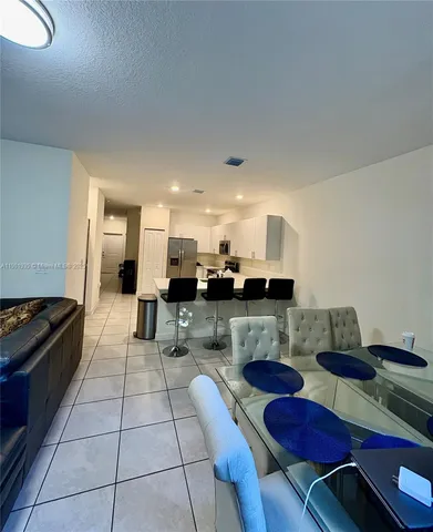 a kitchen with stainless steel appliances kitchen island granite countertop a stove a sink a microwave and a refrigerator