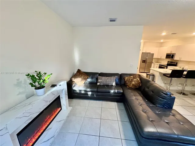 a living room with furniture and a potted plant