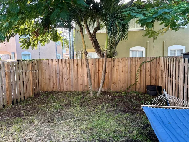 a view of a backyard with potted plants and large tree