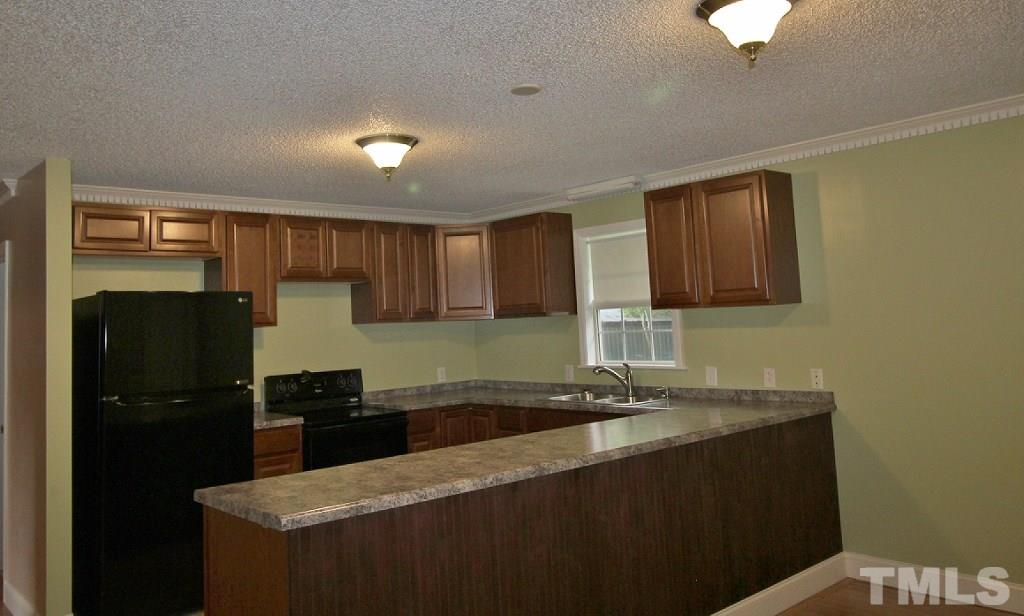 7360 Boykin Road Sims, NC 27880 - Photo 4 of 4 a kitchen with a sink refrigerator and cabinets