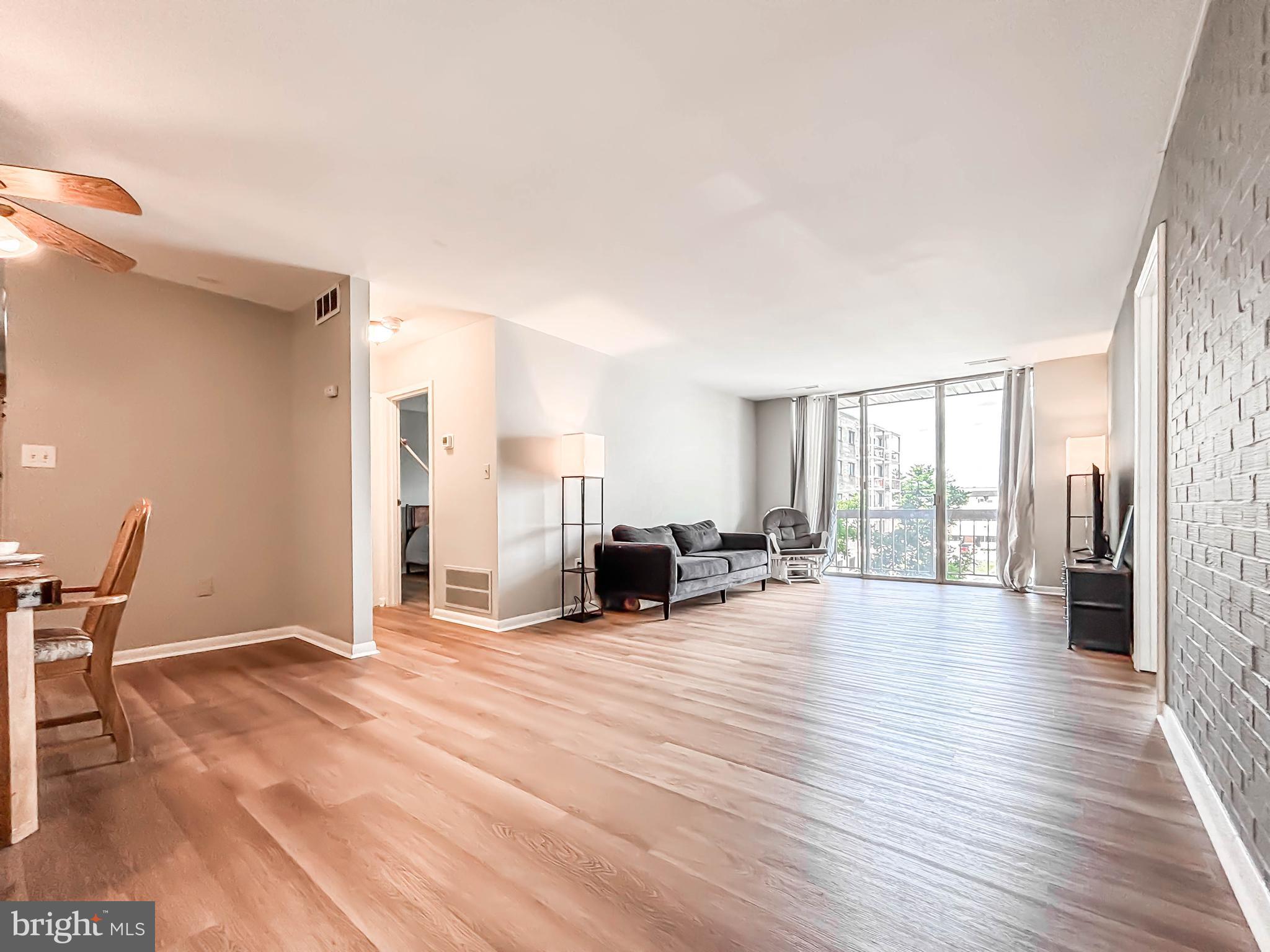 130 Slade Avenue, Unit 414 Baltimore, MD 21208 - Photo 14 of 48 a view of a livingroom with furniture wooden floor and windows