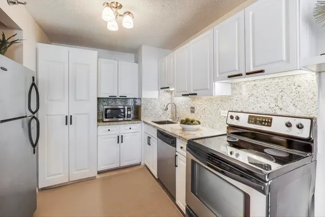 a kitchen with appliances a sink and cabinets