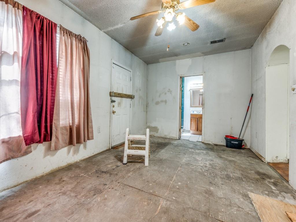 4942 Terry Street Dallas, TX 75223 - Photo 14 of 25 Unfurnished room with visible vents, arched walkways, a ceiling fan, and a textured ceiling