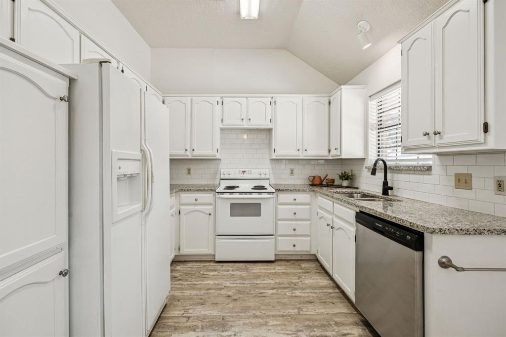 2900 Christopher Drive Denton, TX 76209 - Photo 16 of 25 a kitchen with white cabinets and white appliances