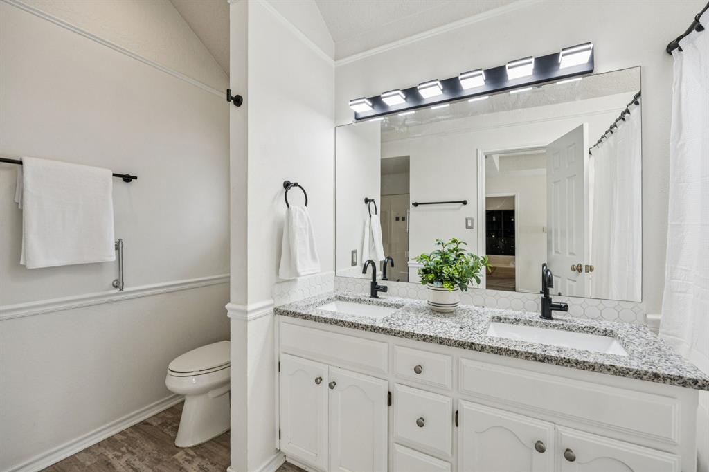 2900 Christopher Drive Denton, TX 76209 - Photo 7 of 25 a bathroom with a granite countertop sink a toilet and shower